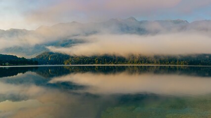 Aerial view of Bohinj lake surrounded by dense trees in morning