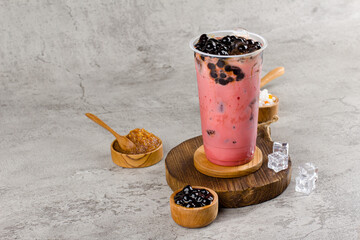 Boba or tapioca pearls is taiwan bubble milk tea in plastic cup with red velvet flavor on texture  background, summers refreshment.