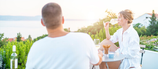 Ehepaar genießt den Sonnenuntergang bei einem kühlen Glas Weisswein