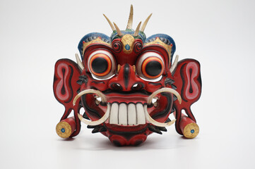 Balinese demon mask, front view on white background.