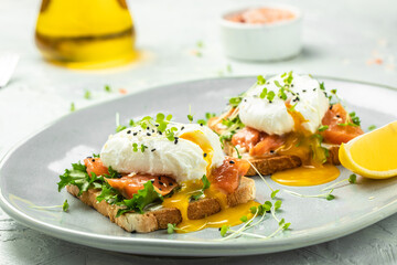 Poached egg with salmon and guacamole on toast. Delicious breakfast. Food recipe background. Close up