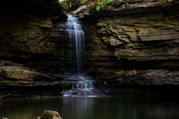 Closeup shot of a beautiful waterfall flowing through the stones