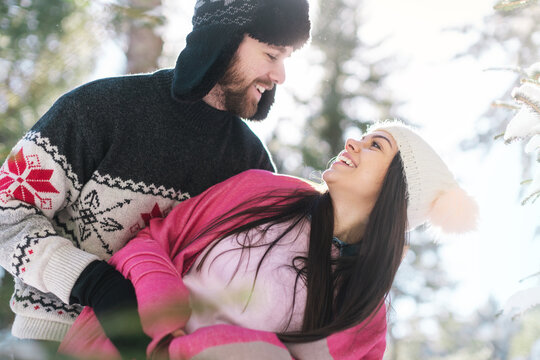 Smiling beautiful couple looking at each other in warm clothes