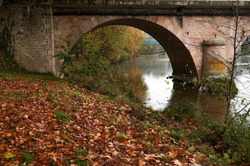 Beautiful shot of a bridge reflecting on a river surface during autumn
