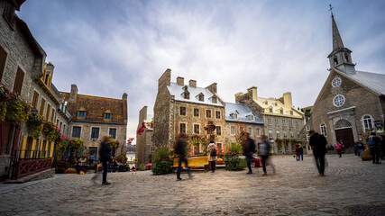 Obraz premium In the heart of the old town of Quebec there is the Place Royale where tourists admire the cobbled streets and stone houses of New France.