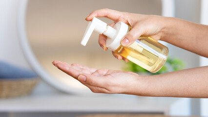 Woman with bottle of soap in bathroom