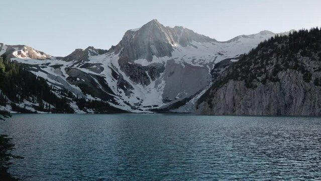 Scenic snowy mountain in the background of a lake at sunrise