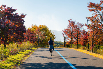 紅葉した木々の間をランニングする男性　信州スカイパーク