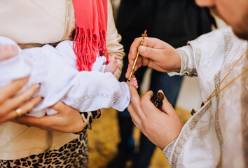 The priest in the church conducts the ceremony, the ritual of anointing the child's feet. Close-up...