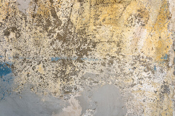 Old scratched stained stucco wall with paint remains texture background