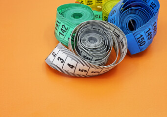 colorful measuring tapes on a brown background