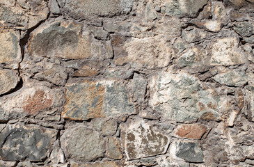 Wall old, background of cracked stones of different shapes.