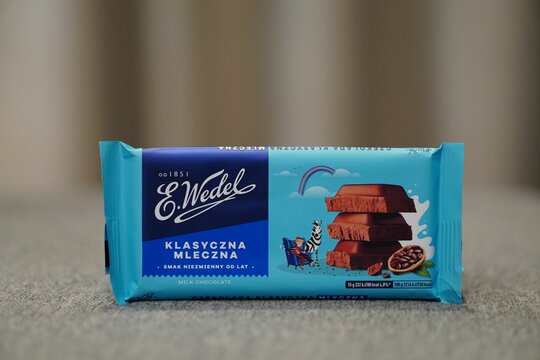 Closeup of Polish E. Wedel brand classic milk chocolate bar packed in blue paper.