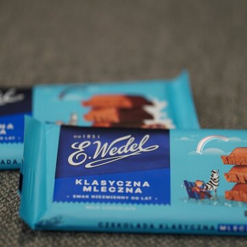 Vertical closeup of Polish E. Wedel brand classic milk chocolate bars packed in blue paper.