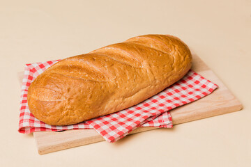 Freshly baked bread on cutting board against white wooden background. perspective view bread with copy space