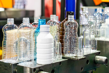 various sample transparent plastic bottle and other color with  preform raw material place on metal...