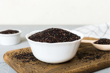 quinoa seeds in bowl and spoon on colored background. Healthy kinwa in small bowl. Healthy superfood
