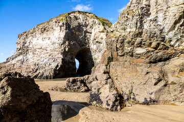 Rocks and caves on Perranporth Beach in Cornwall, on a sunny day