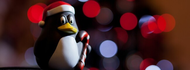 Closeup of a penguin toy with Santa Claus hat on bokeh background