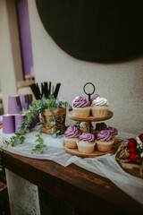 Vertical shot of a sweet bar with gourmet purple and white cupcakes