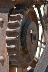 Vertical shot of a rusted gear on old farm equipment