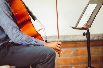 Fototapeta na wymiar Closeup of a man sitting and playing a cello