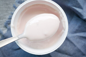 spoon pick fresh yogurt in a bowl on table 