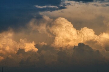 Closeup of sunlit, white clouds on the blue sky background