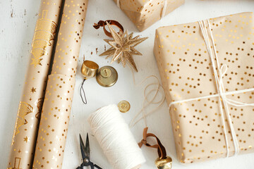 Stylish golden christmas gifts flat lay. Modern wrapped christmas gift boxes, festive paper, golden...