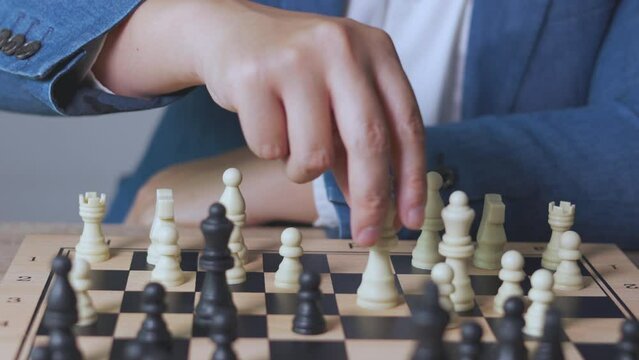 Close up 4K of businessman's hand picking the king chess to kill the enemy king to win the game. It shows concept of competition with strategic business planning of teamwork for winning the battle.