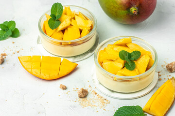 greek yogurt and mango in glass jars on a light background. Restaurant menu, dieting, cookbook recipe top view