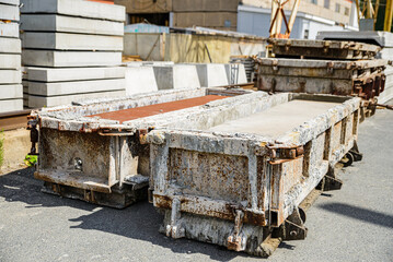 Old rusty metal molds for the production of reinforced concrete products.