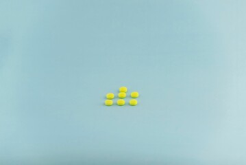Bunch of yellow medical pills isolated on a blue background