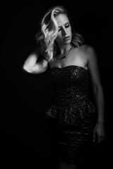 Naklejka premium Vertical greyscale shot of an attractive female model in an elegant black dress