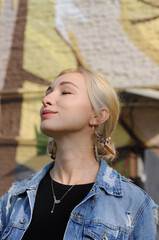 Close-up portrait of pretty blonde girl in hippie feather earrings