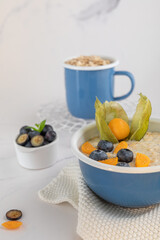 Smaczna owsianka z borówkami w niebieskiej misce. © Dorota
