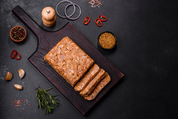 Tasty meat brawn or roll on a wooden cutting board with spices and herbs