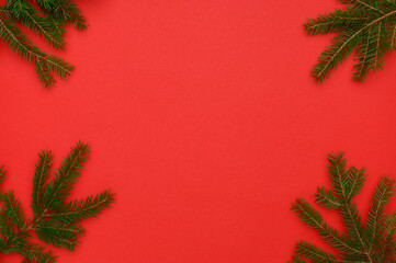 Fototapeta na wymiar Christmas, winter composition. Frame of fir branches on a red background.Concept of christmas, winter, new year.Flat lay