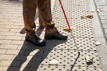 Close-up of a blind man with a walking stick. Detects tactile tiles for self-orientation while...