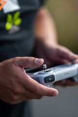 Vertical closeup of the hands of a person with controller