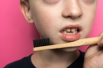 a bamboo toothbrush against the background of the face of a small child of European appearance. baby teeth