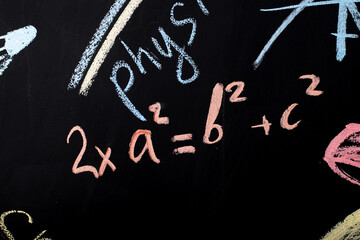 Fototapeta na wymiar mathematical formulas written in chalk on a slate wall