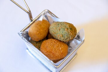 Top closeup of Arancini balls on the foil pan on the white background