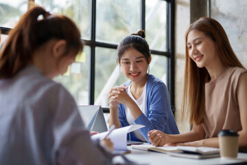 Group of young Asian business woman are meeting to present a new roadmap in product design with laptop computers in the office.