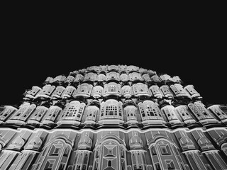 Fototapeta premium Low-angle grayscale of the Hawa Mahal Palace in Jaipur India with unique sandstone architecture