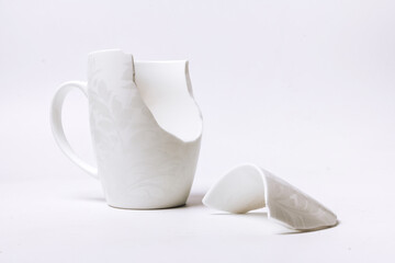 broken white cup with a pattern, on a white background
