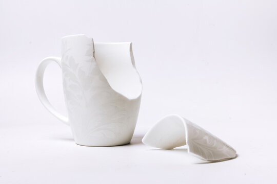 Broken White Cup With A Pattern, On A White Background