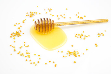 spoon with fresh honey and pollen spilled on a white background. organic vitamin food