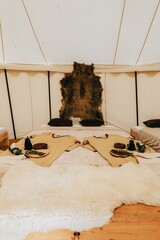 Vertical shot of the interior of a tent with equipment,traditional robes,and beds for luxury camping