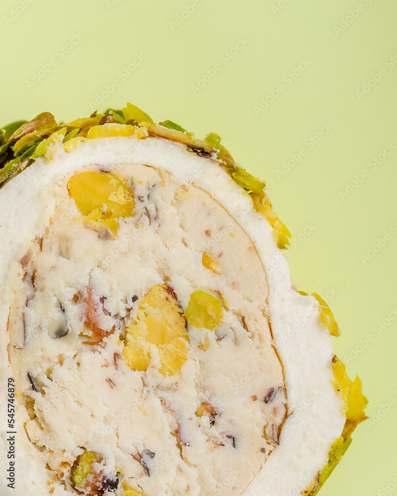 Poster macro view of a pice of nougat with nuts on green background